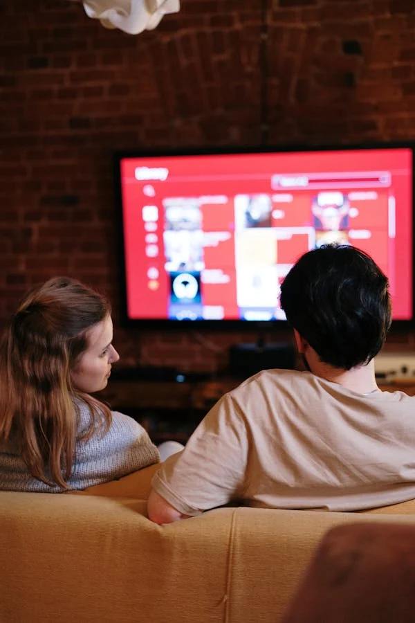 Two GigoStream subscribers watching a live channel together on a wall-mounted television